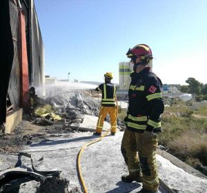 Bomberos en las labores de extinción del incendio en una nave industrial de Crevillent. Bomberos en las labores de extinción del incendio en una nave industrial de Crevillent.