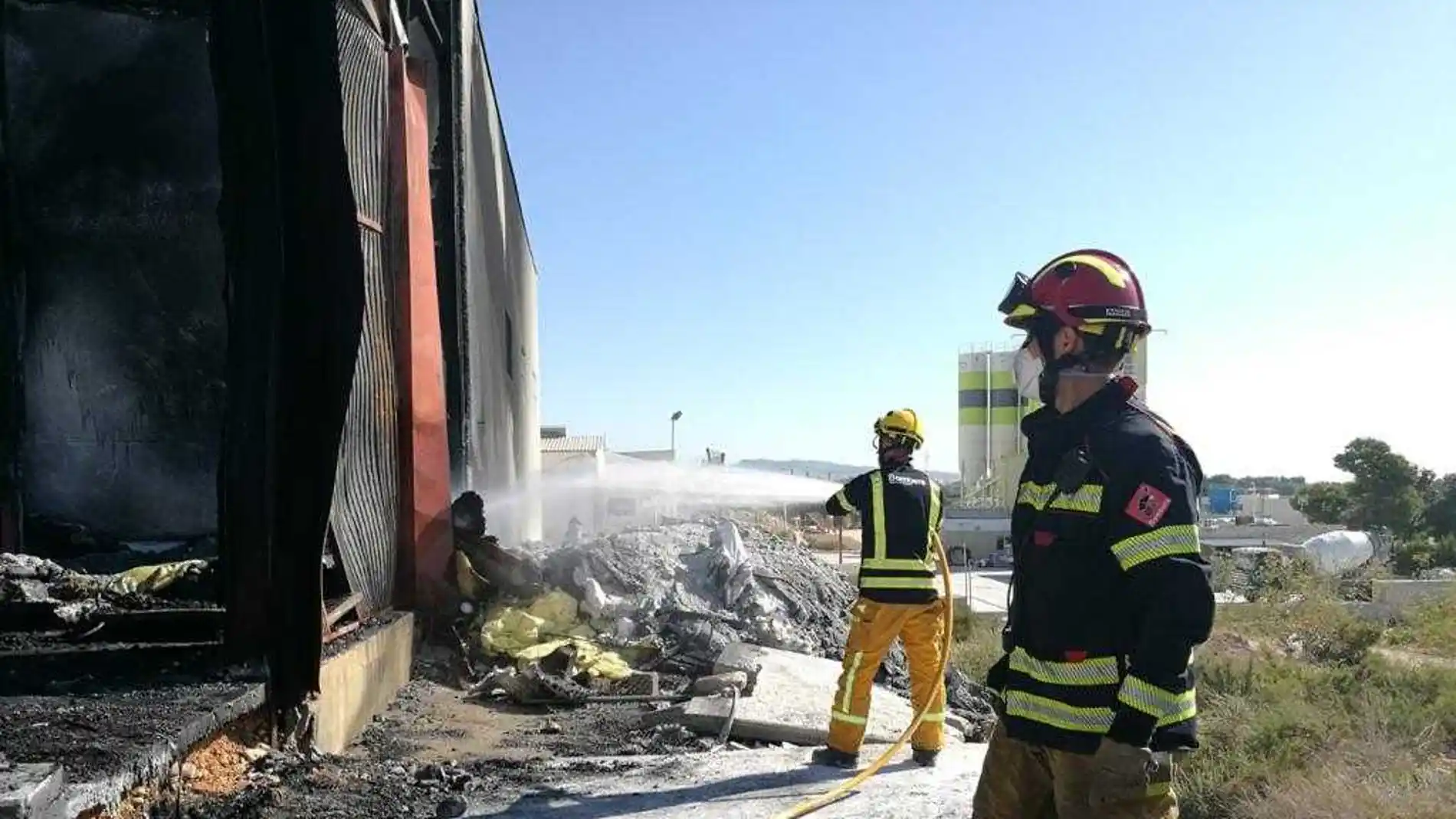 Bomberos en las labores de extinción del incendio en una nave industrial de Crevillent. 
