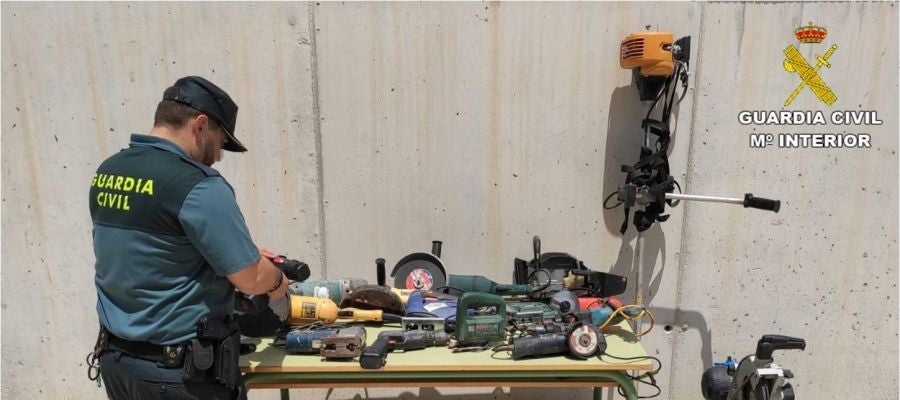 Agente d ela Guardia Civil junto a efectos recueprados en la operación policial. Agente d ela Guardia Civil junto a efectos recueprados en la operación policial.