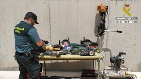 Agente d ela Guardia Civil junto a efectos recueprados en la operación policial. Agente d ela Guardia Civil junto a efectos recueprados en la operación policial.