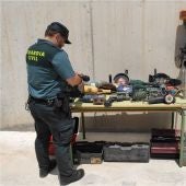 Agente d ela Guardia Civil junto a efectos recueprados en la operación policial.