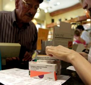 Un hombre adquiere varios medicamentos en una farmacia Un hombre adquiere varios medicamentos en una farmacia