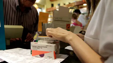 Un hombre adquiere varios medicamentos en una farmacia Un hombre adquiere varios medicamentos en una farmacia