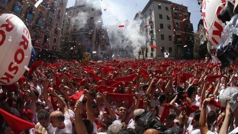 Cientos de personas alzan su pa&ntilde;uelo rojo durante el chupinazo de San Ferm&iacute;n en Pamplona.