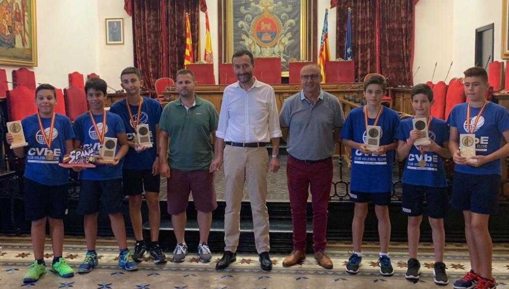 El alcalde de Elche, Carlos González, junto al concejal de Deportes, Vicente Alberola; el presidente del Club Voleibol Elche, David Agulló; y los campeones de España en categoría alevín masculina: Justo, Izan, Daniel, Ariel, Adrián y Noel.