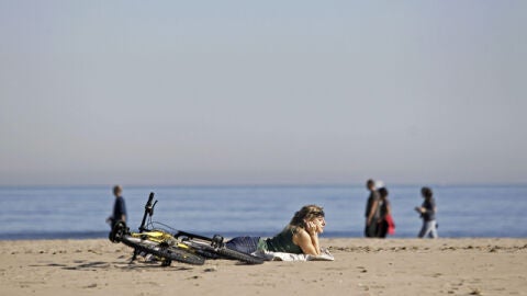 Una chica toma el sol en la Playa de la Malvarrosa (Valencia)