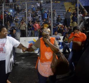Aficionados ingresan al campo y se protegen de los gases lacrimógenos lanzados por las autoridades, debido a los disturbios a las afueras del Estadio Nacional por la cancelación del clásico entre Olimpia y Motagua, en Tegucigalpa Aficionados ingresan al campo y se protegen de los gases lacrimógenos lanzados por las autoridades, debido a los disturbios a las afueras del Estadio Nacional por la cancelación del clásico entre Olimpia y Motagua, en Tegucigalpa