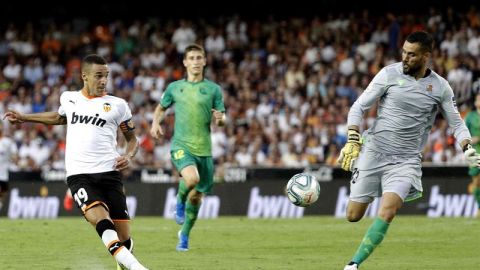 El delantero del Valencia CF Rodrigo Moreno trata de superar la salida del portero de la Real Sociedad Moy&aacute;