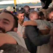 Abrazos, sonrisas y gritos de alegría en el Open Arms tras enterarse de que los migrantes desembarcarán en Lampedusa