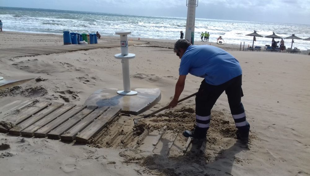 Un operario de Urbaser repara una pasarela en la playa de Arenales del Sol.