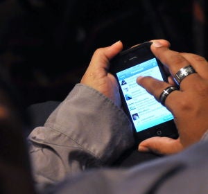 Un joven revisa su teléfono móvil Un joven revisa su teléfono móvil