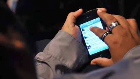 Un joven revisa su teléfono móvil Un joven revisa su teléfono móvil