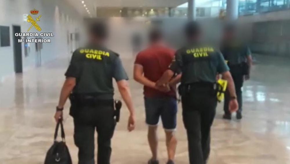 Agentes de la Guardia Civil con uno de los detenidos en el aeropuerto de El Altet de Elche.