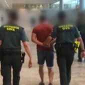 Agentes de la Guardia Civil con uno de los detenidos en el aeropuerto de El Altet de Elche.