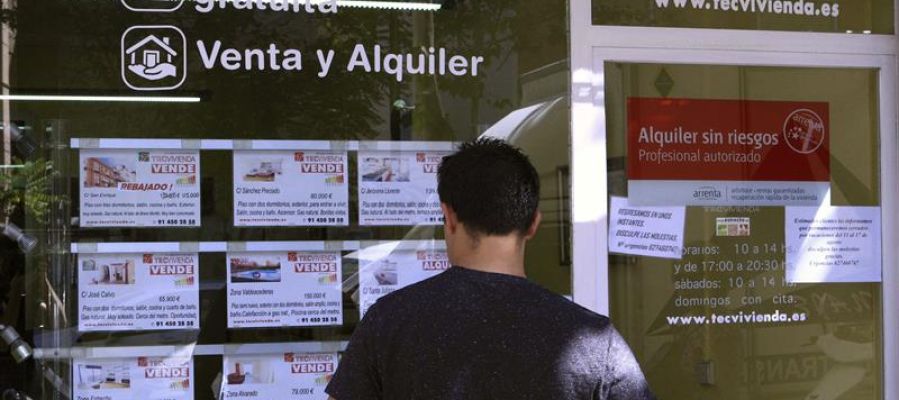 Un hombre mira las viviendas en venta en una inmobiliaria Un hombre mira las viviendas en venta en una inmobiliaria