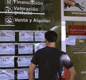 Un hombre mira las viviendas en venta en una inmobiliaria Un hombre mira las viviendas en venta en una inmobiliaria