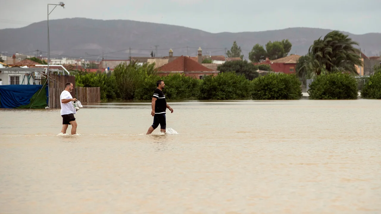 Dos personas caminan por una zona inundada tras el paso de la gota fría