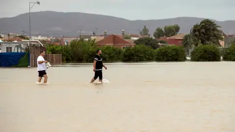 Dos personas caminan por una zona inundada tras el paso de la gota fría Dos personas caminan por una zona inundada tras el paso de la gota fría