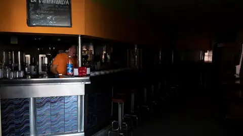 Un empleado de una cafetería de Santa Cruz de Tenerife intenta trabajar a oscuras mientras espera a que se restablezca el suministro eléctrico la isla. Un empleado de una cafetería de Santa Cruz de Tenerife intenta trabajar a oscuras mientras espera a que se restablezca el suministro eléctrico la isla.