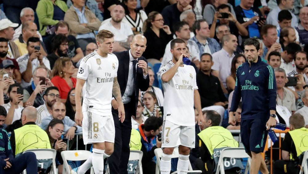 Zidane da instrucciones a Kroos y a Hazard en la banda del Bernabéu