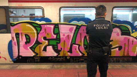 Imagen de archivo de un agente de la Polic&iacute;a Local de Elche frente a un vag&oacute;n con pintadas.