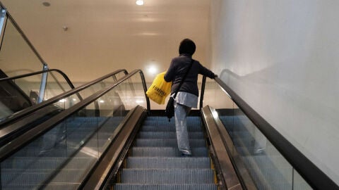 Una mujer sube en unas escaleras mec&aacute;nicas