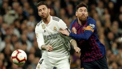 Sergio Ramos y Messi pugnan por el bal&oacute;n durante un Cl&aacute;sico entre Real Madrid y FC Barcelona