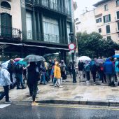Ciudadanos paseando bajo la lluvia en el centro de Palma.