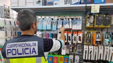 Un agente de la Polic&iacute;a Nacional junto a un expositor de productos.