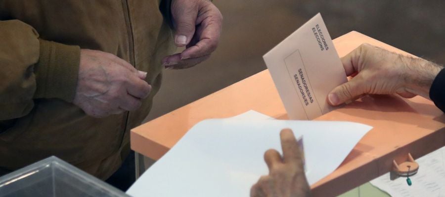 Un ciudadano deposita su voto en un colegio electoral Un ciudadano deposita su voto en un colegio electoral