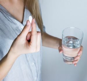 Una mujer se toma una antibiótico Una mujer se toma una antibiótico