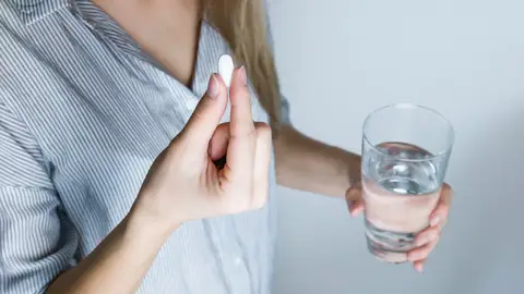 Una mujer se toma una antibiótico Una mujer se toma una antibiótico