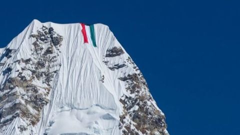 Nirmal Purja extiende una bandera de Kuwait en el Himalaya