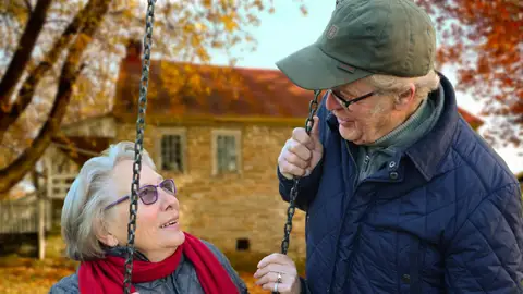 Una pareja de abuelos en un columpio Una pareja de abuelos en un columpio