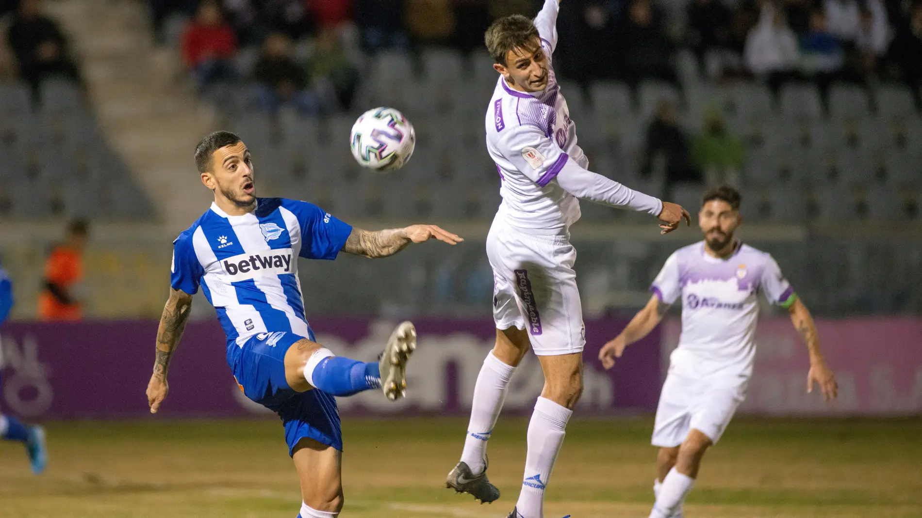  El delantero del Alavés Joselu (iz) disputa la pelota con el jugador del Real Jaén Javier Gutiérrez "Javilillo"