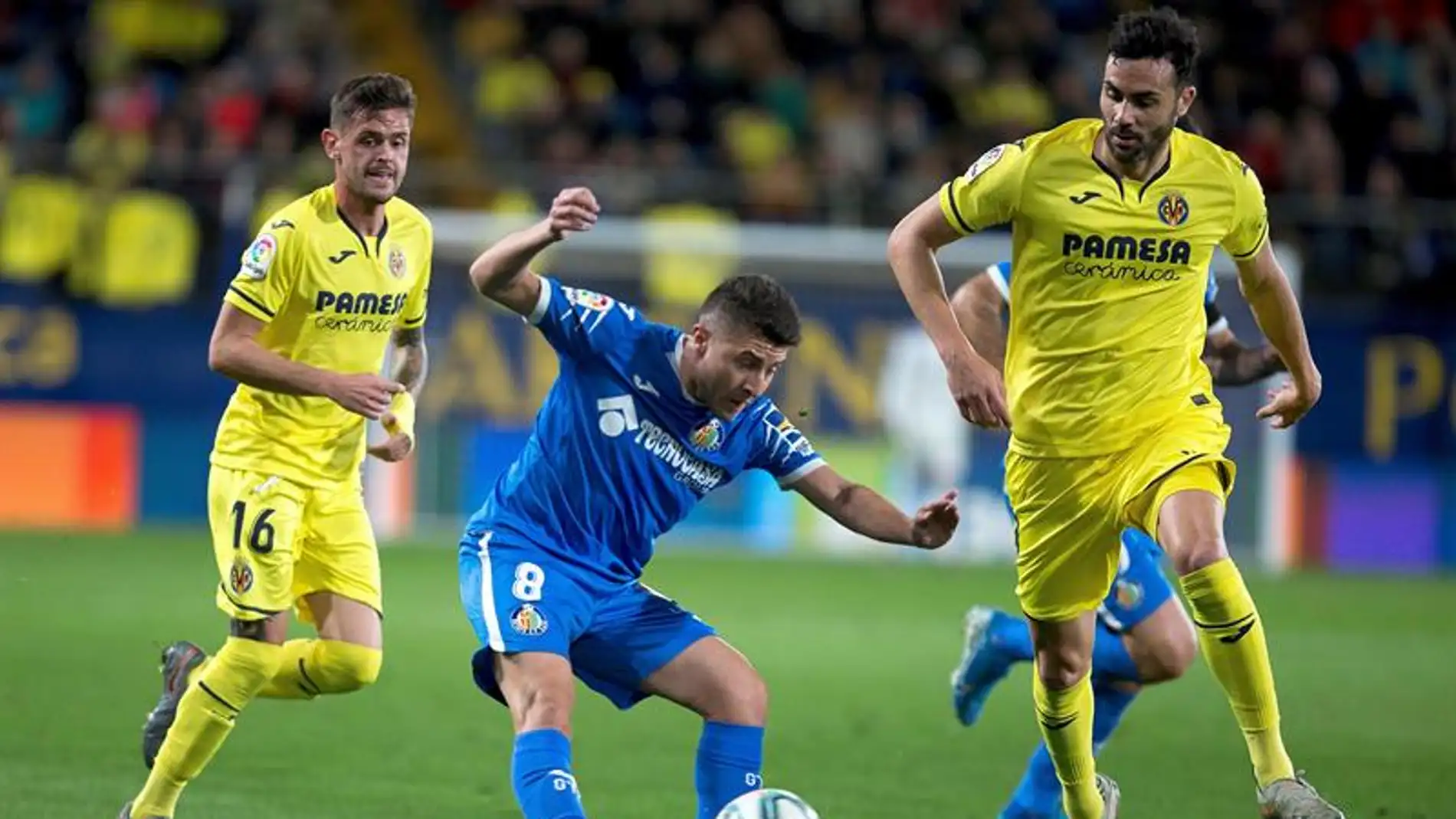 El centrocampista del Getafe Framcisco Portillo juega un balón entre dos jugadores del Villarreal