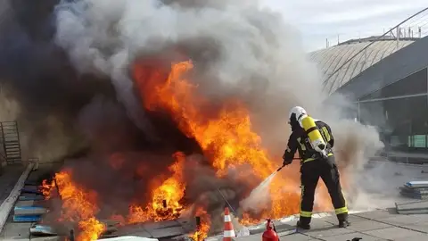 Un bombero en las labores de extinción en el aeropuerto Alicante-Elche. Un bombero en las labores de extinción en el aeropuerto Alicante-Elche.