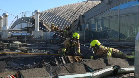Bomberos en las tareas de extinci&oacute;n del incendio en el aeropuerto Alicante-Elche. 