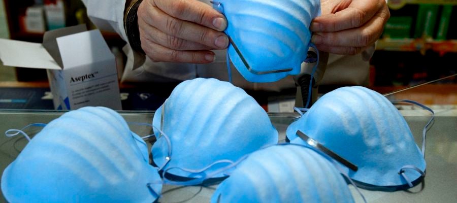 Un hombre manipulando varias mascarillas Un hombre manipulando varias mascarillas