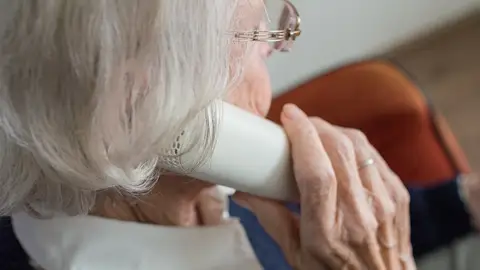 Una anciana hablando por teléfono Una anciana hablando por teléfono