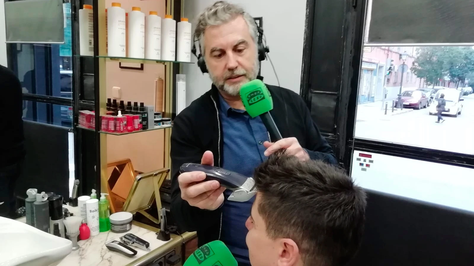 Carlos Alsina cortando el pelo al peluquero que rapó al grupo de niños solidarios con su amigo