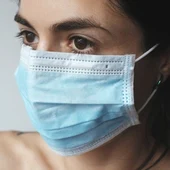 Una mujer con una mascarilla quirúrgica Una mujer con una mascarilla quirúrgica