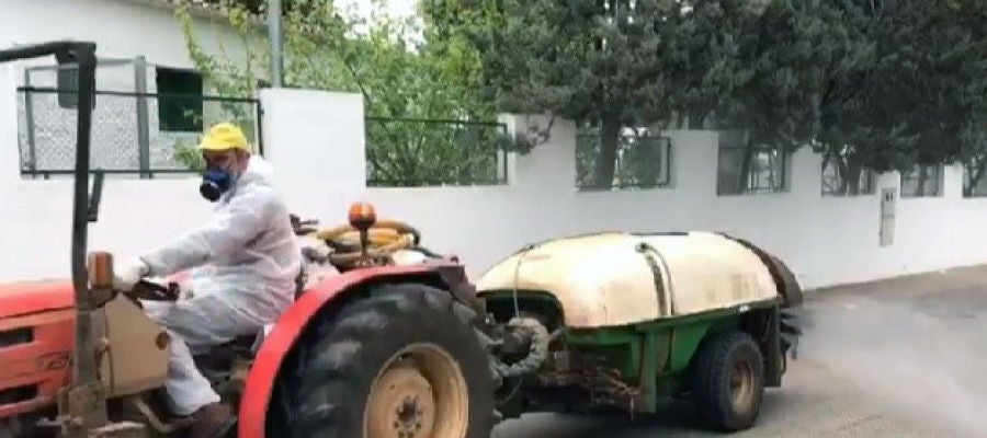 Tractor con cisterna y atomizador desinfectando las calles de una localidad. Tractor con cisterna y atomizador desinfectando las calles de una localidad.