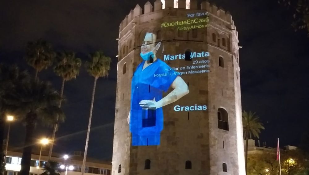 La fotografía de una profesional de Enfermería proyectada en la Torre del Oro