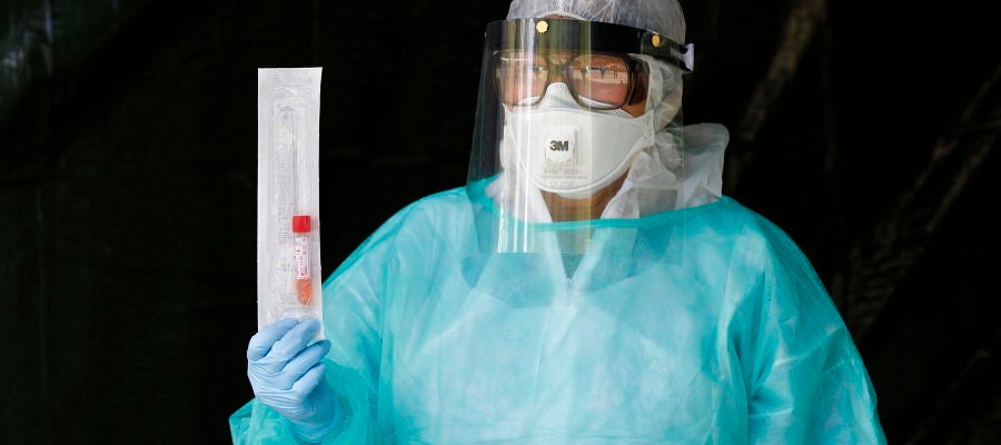 Un profesional sanitario sostiene una muestra de un paciente Un profesional sanitario sostiene una muestra de un paciente