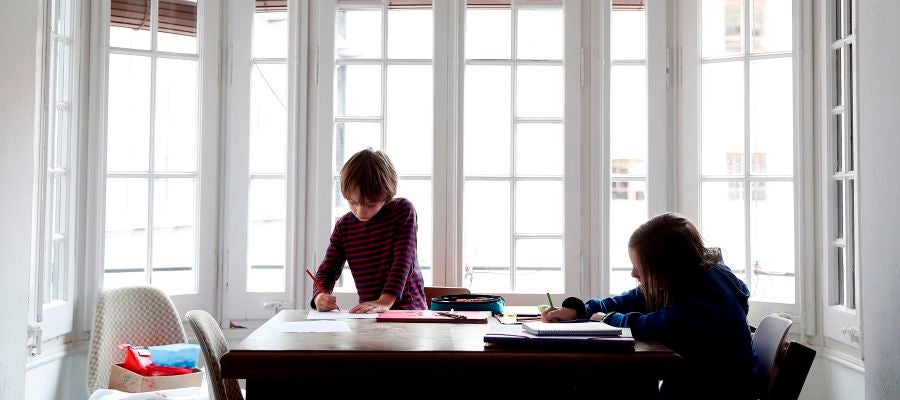 Dos niños hacen sus deberes en su casa Dos niños hacen sus deberes en su casa