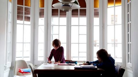 Dos ni&ntilde;os hacen sus deberes en su casa