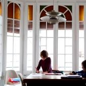 Dos niños hacen sus deberes en su casa