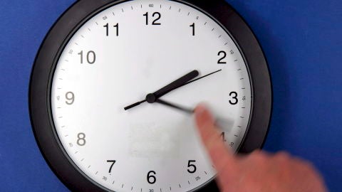 Una persona cambia la hora de un reloj