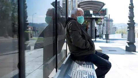 Un hombre con una mascarilla en una parada de autobús en Ourense. Un hombre con una mascarilla en una parada de autobús en Ourense.